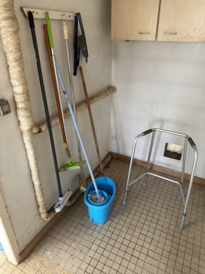 une serpillière et un seau dans un coin de la pièce