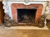 une cheminée au milieu d'une pièce, avec des statues sur le manteau de cheminée