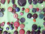 many different types of buttons on a green surface