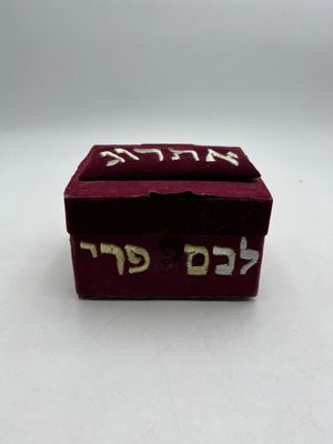 an image of a small red box with hebrew writing on it