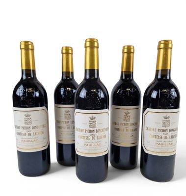 four bottles of wine are lined up on a white surface