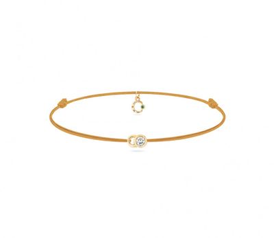 un gros plan d'un bracelet en or orné d'un diamant