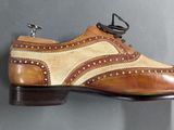pair of brown and tan shoes hanging on a gray wall
