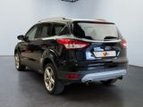 the rear end of a black ford escape parked in a showroom