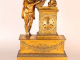 une statue représentant un homme jouant d'un instrument de musique à côté d'une horloge