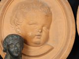 two plates with heads of children on them and a bust of a child