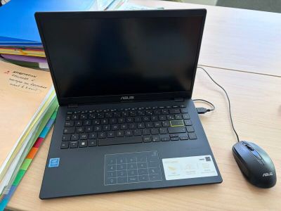 a laptop computer sitting on a desk next to a mouse