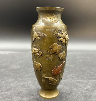 un vase en or orné de fleurs, posé sur une table