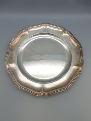 une assiette en argent posée sur un plateau blanc, bordée d'argent