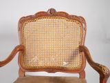 an image of a wooden chair with a cane back and a brown seat