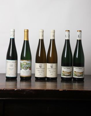 plusieurs bouteilles de vin sont alignées sur une table en bois