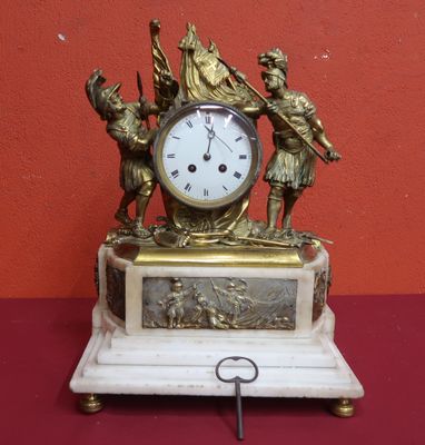 a clock that is sitting on a table with a key in it