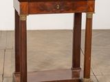une vieille table en bois avec un plateau en marbre, posée sur un parquet