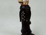 une figurine représentant un homme avec un oiseau sur la tête