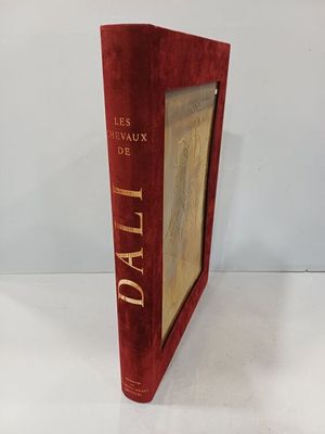 un vieux livre posé sur une table blanche à côté d'un mur blanc