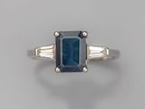 un gros plan d'une bague sertie d'un saphir bleu et de deux pierres taillées en baguette