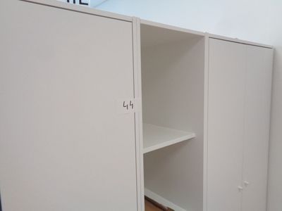 une armoire blanche avec une étagère, dans un coin de la pièce