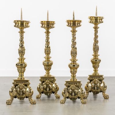 a set of four antique brass candlesticks