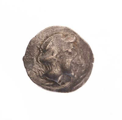 une vieille pièce de monnaie sur laquelle figure un visage, sur un fond blanc