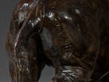 bronze statue of a bull with a long neck and large horns