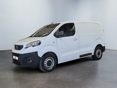 the small white van is parked in a large room