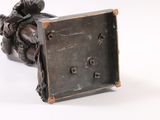 a bronze statue of a man holding a square object