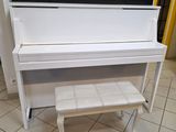 un piano blanc et un banc dans une pièce