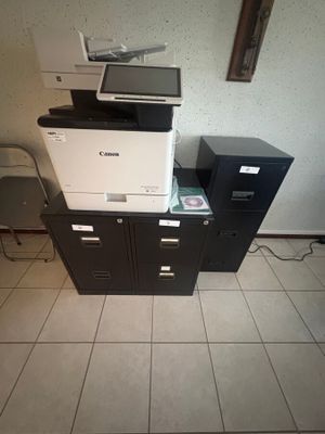 une pile de fournitures de bureau posée sur un sol carrelé