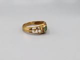 a close up of a gold ring with a green stone