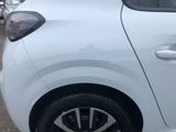 a white car parked in a parking lot with other cars in the background