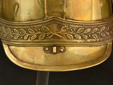 a gold helmet on a stand with a black background