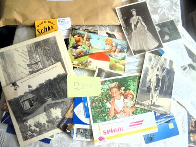 une pile de vieilles photos et de cartes postales sur un lit