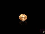 a close up of a yellow diamond on a black surface
