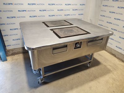 une table en acier inoxydable sur laquelle sont posés trois récipients