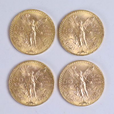 four gold coins with a statue on them sitting on a white surface