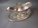 a silver plate with a spoon and saucer on it