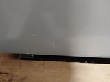 a white refrigerator sitting on top of a wooden table