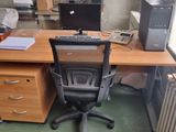 a desk with a chair and a computer on it