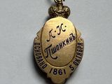 an image of a small gold medal with the name of a woman