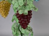 a glass vase with a bunch of grapes on it