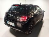 the back end of a small black car parked in a garage