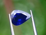 un gros plan d'un diamant bleu tenu par une pince