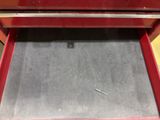 a red drawer that has a nail in it