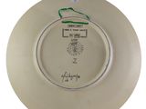 a white plate with a green handle and a picture on it