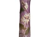un vase violet orné de fleurs blanches, posé sur une surface blanche