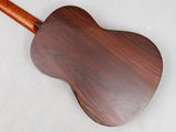 a close up of a wooden guitar on a white surface
