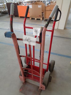 a red hand truck with a price tag on it in a warehouse
