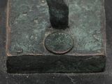 a bronze statue of a bird on a base with a coin