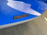 a close up of a blue car with a number plate on it