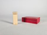 une petite boîte rouge et une petite boîte rouge posées sur une surface blanche